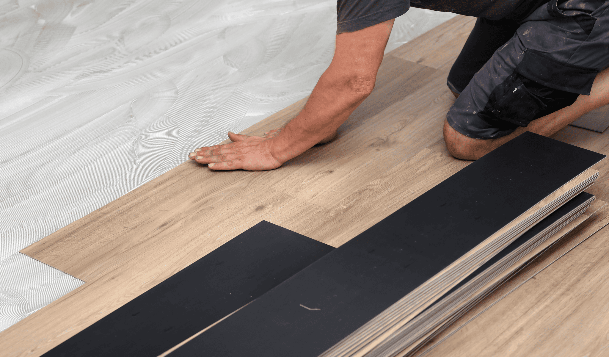 Man installing glue down vinyl flooring